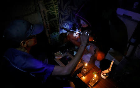 A drug user inhales "Shabu", or methamphetamine, at a drug den in Manila, Philippines February 13, 2017. REUTERS/Erik De Castro