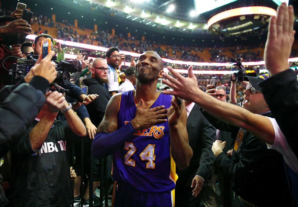 Kobe Bryant puts his hand over his heart and grins as he leaves the court in his final regular-season NBA game in Boston on Dec. 30, 2015.