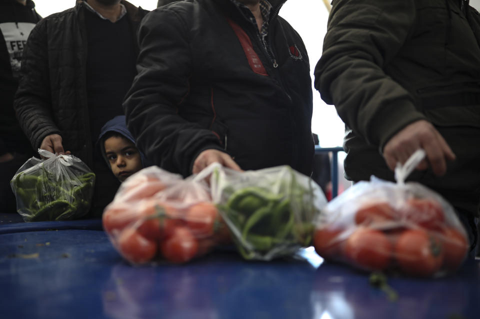 In this Sunday, Feb. 17, 2019 photo, shoppers wait in line to buy groceries at a government-run market selling spinach, tomatoes and peppers at discounted prices in an Istanbul neighbourhood. Turkey's President Recep Tayyip Erdogan's government has set up dozens of these temporary stalls in Turkey's largest cities in a bid to mitigate the effects of soaring food prices that have stung households. The move comes just over a month before Erdogan faces local elections on March 31, when runaway prices and an economic downturn could cost his ruling party some key municipal seats. (AP Photo/Emrah Gurel)