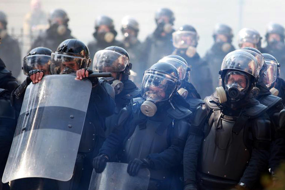 Riot police stand guard are seen during an anti-government rally in Tirana, Albania, Thursday, March 21, 2019. Thousand opposition protesters have gathered in front of Albania's parliament building calling for the government's resignation and an early election. Rally is part of the center-right Democratic Party-led opposition's protests over the last month accusing the leftist Socialist Party government of Prime Minister Edi Rama of being corrupt and linked to organized crime. (AP Photo/ Hektor Pustina)