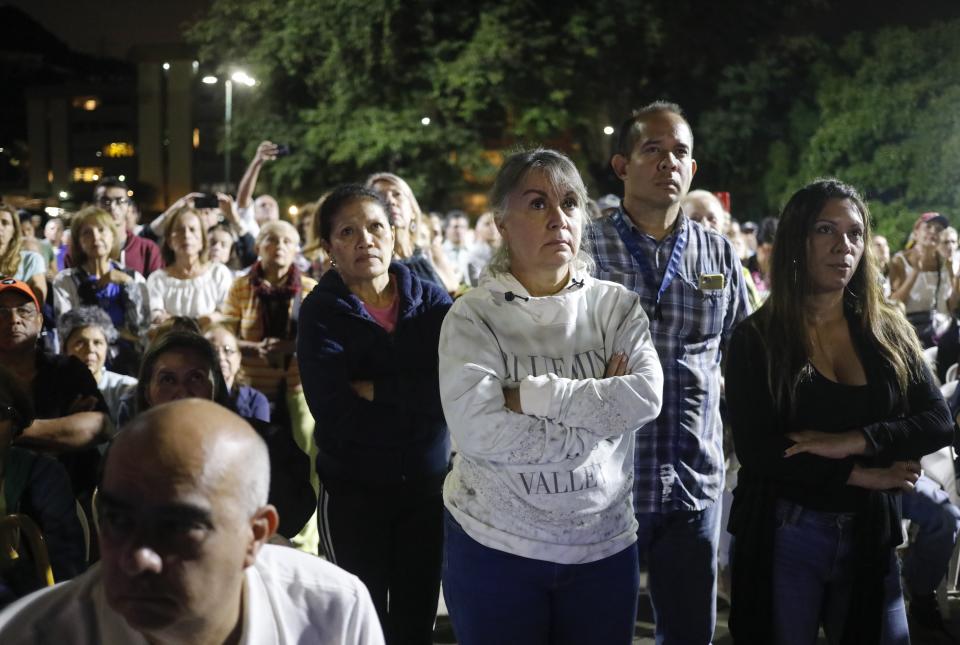 Supporters of Venezuelan opposition leader and self-proclaimed interim president Juan Guaido, listens to him during a citizen's meeting in Caracas, Venezuela, Wednesday, Nov. 13, 2019. Guaido is calling people across the crisis-torn nation to flood the streets for protests nearly a year since launching an urgent campaign to push President Nicolás Maduro from power. (AP Photo/Ariana Cubillos)