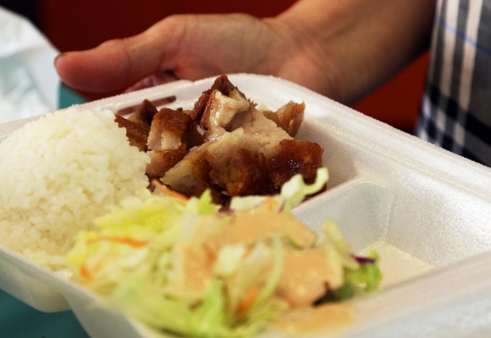 A polystyrene foam box holds an order of roast pork, rice and salad on March 14, 2019