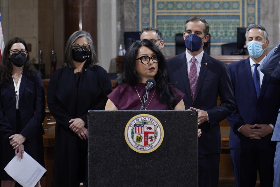 FILE - Los Angeles City Council President Nury Martinez, at podium, and Mayor Eric Garcetti, standing to her right, are seen during a news conference at Los Angeles City Hall in Los Angeles on April 1, 2022. The president of the Los Angeles City Council resigned from the post in October after she was heard making racist comments and other coarse remarks in a leaked recording of a conversation with other Latino leaders. (AP Photo/Damian Dovarganes, File)