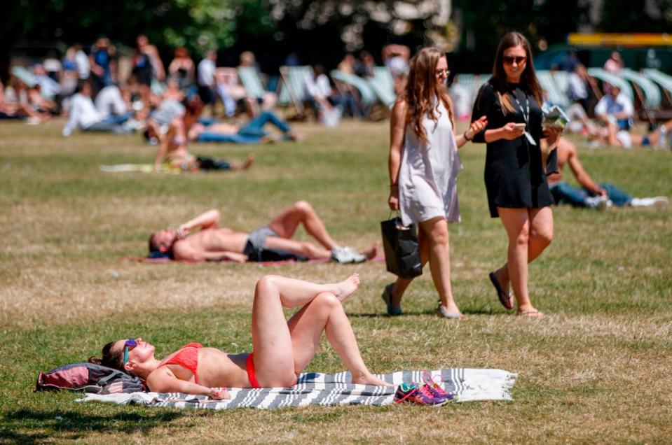 People make the most of the warm weather and bask in the sunshine in Green Park (AFP/Getty Images)