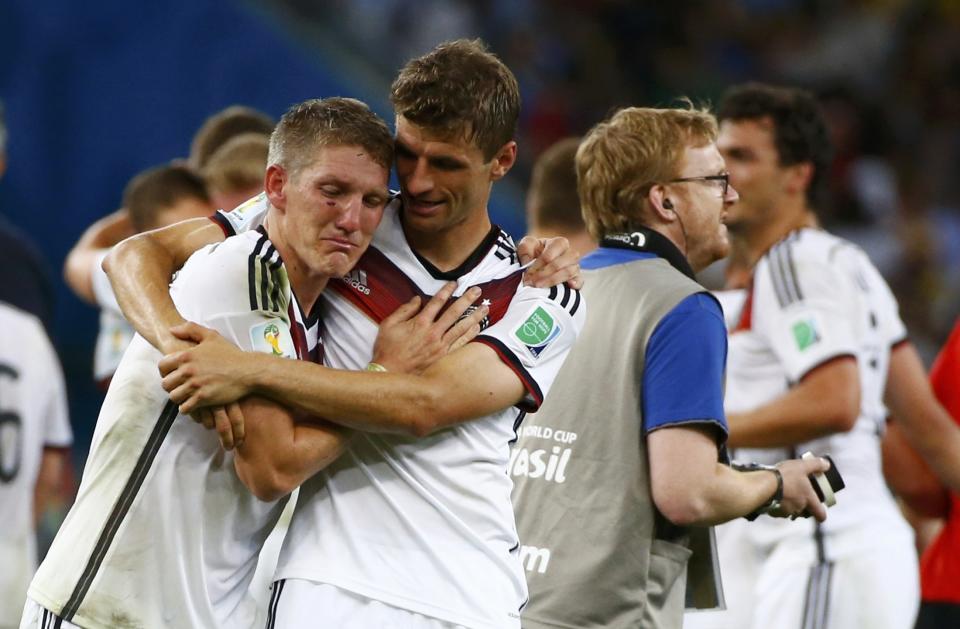 Germany's Bastian Schweinsteiger and Thomas Mueller hug to celebrates after winning the 2014 World Cup final between Germany and Argentina at the Maracana stadium