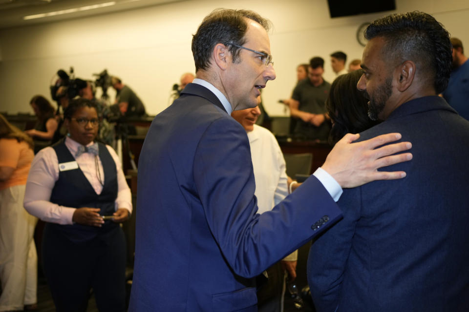 Colorado Attorney General Phil Weiser, left, greets A.J. Straikh after they spoke at a news conference Friday, June 30, 2023, in Denver, about the U.S. Supreme Court ruling that allows a Colorado Christian graphic artist who wants to design wedding websites to refuse to work with same sex couples. (AP Photo/David Zalubowski)