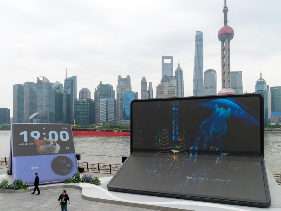 People walk by installations advertising Vivo X Fold 2 foldable smartphone and X Flip foldable smartphone at The Bund on April 11, 2023 in Shanghai, China.