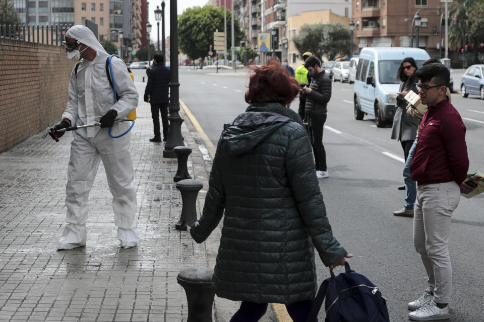 Soldados de la UME desinfectando calles en Valencia, este miércoles 18 de marzo, ante la atenta mirada de transeúntes. (Photo by Jose Miguel Fernandez/NurPhoto via Getty Images)