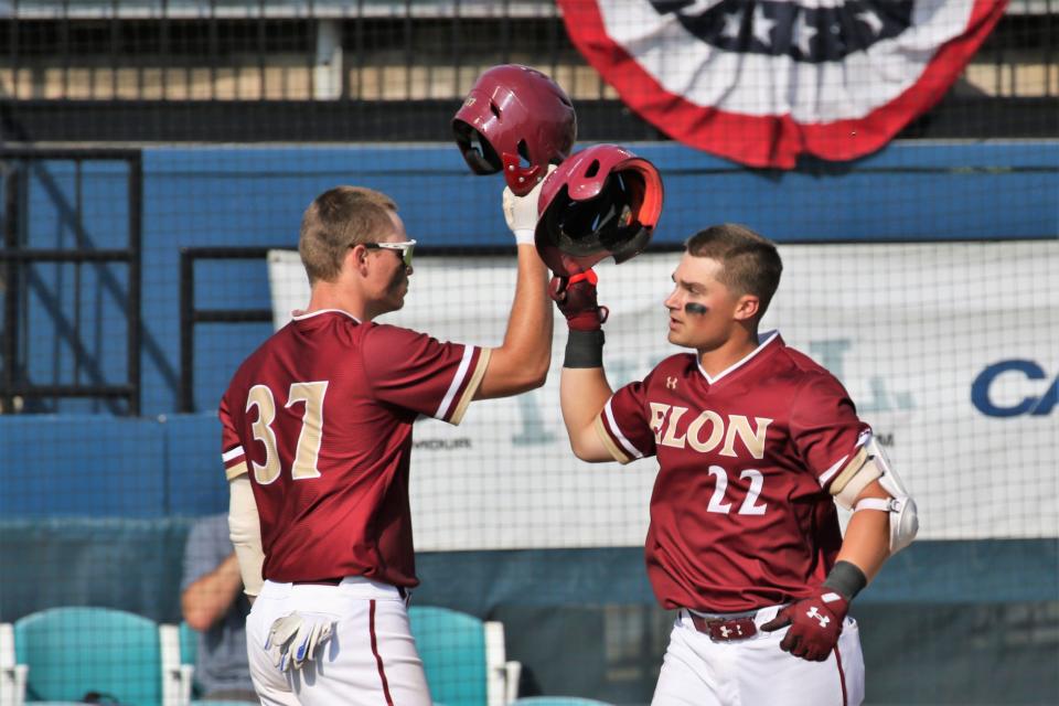 Elon’s Cole Reynolds, left, greets teammate Nick Cicci during the Phoenix’s victory against William & Mary to open the CAA baseball tournament on Wednesday.