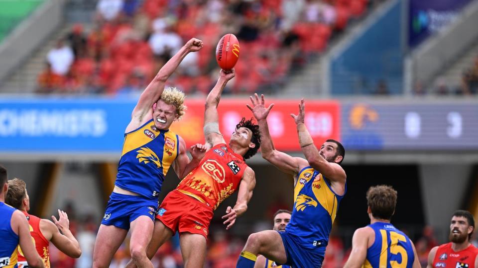 Players from both teams leap high for the ball.