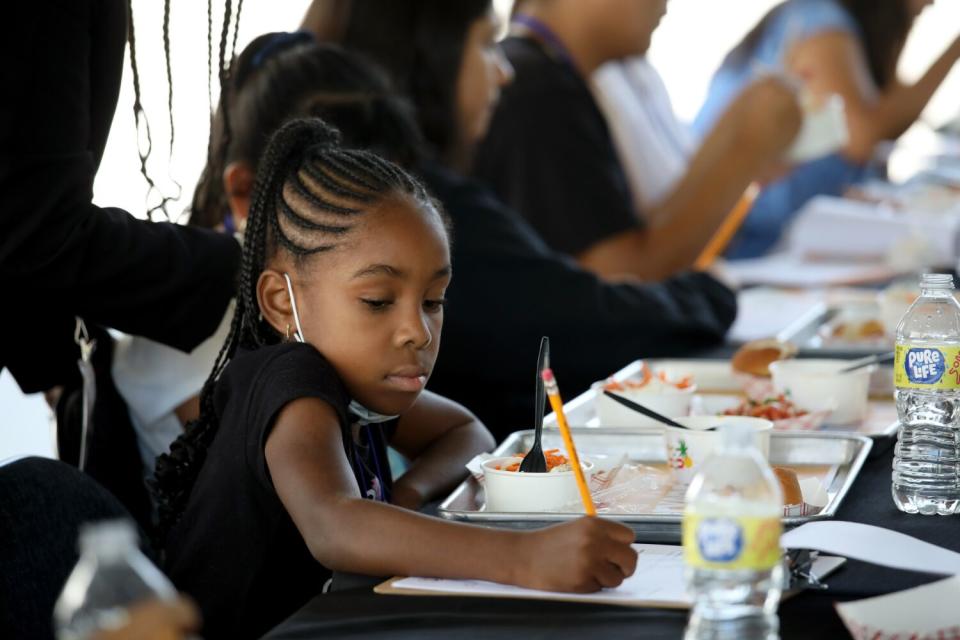 A student fills out a form after eating in a cafeteria.