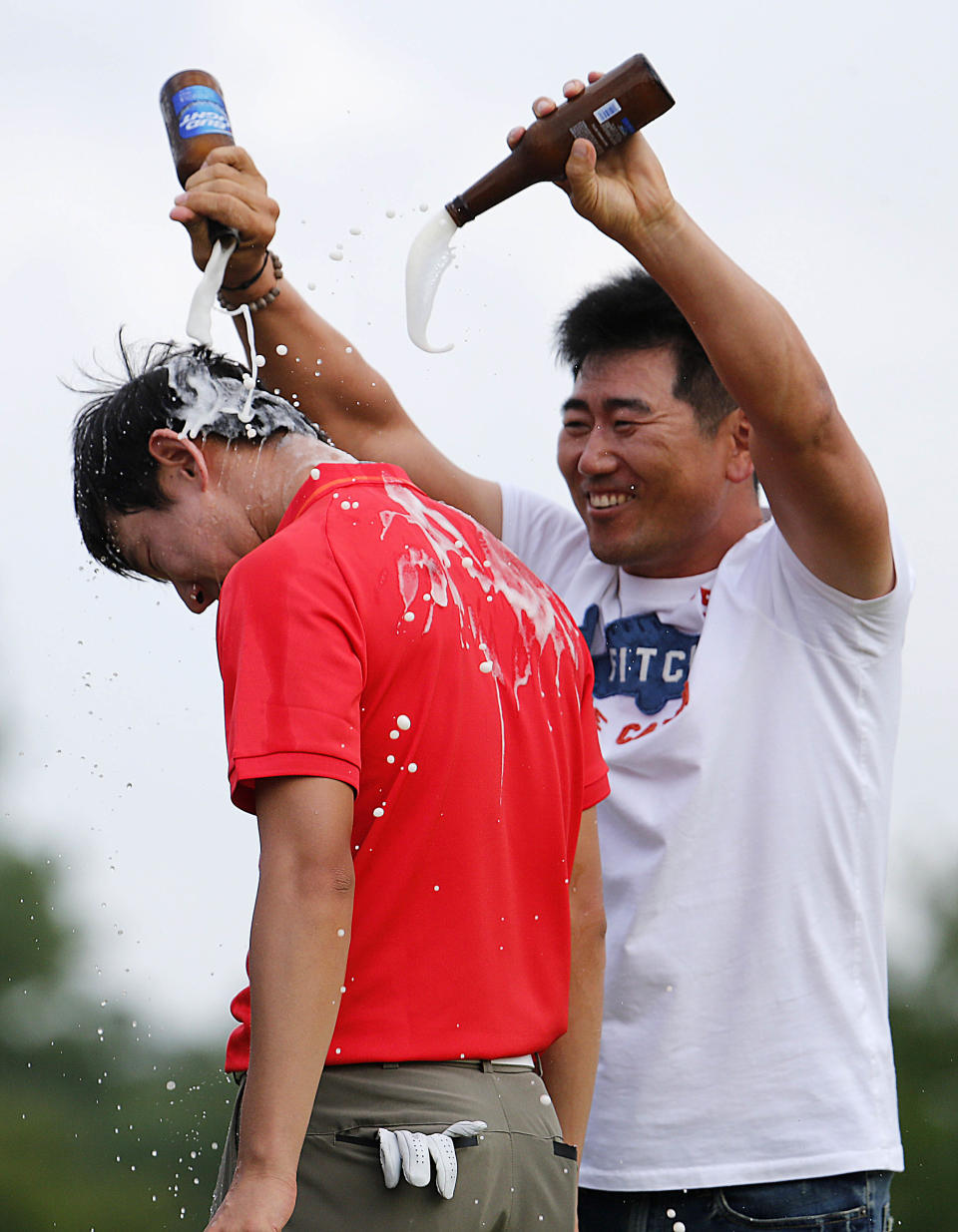 South Korean golfers Y.E. Yang douses Noh Seung-yul, right, with beer on the 18th green after Noh won the Zurich Classic golf tournament at TPC Louisiana in Avondale, La., Sunday, April 27, 2014.(AP Photo/Bill Haber)