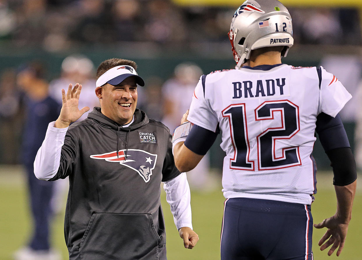 New England Patriots offensive coordinator Josh McDaniels high fives Tom Brady before their game against the New York Jets at MetLife Stadium on Oct. 21, 2019, in East Rutherford, New Jersey. (Matt Stone/MediaNews Group/Boston Herald)