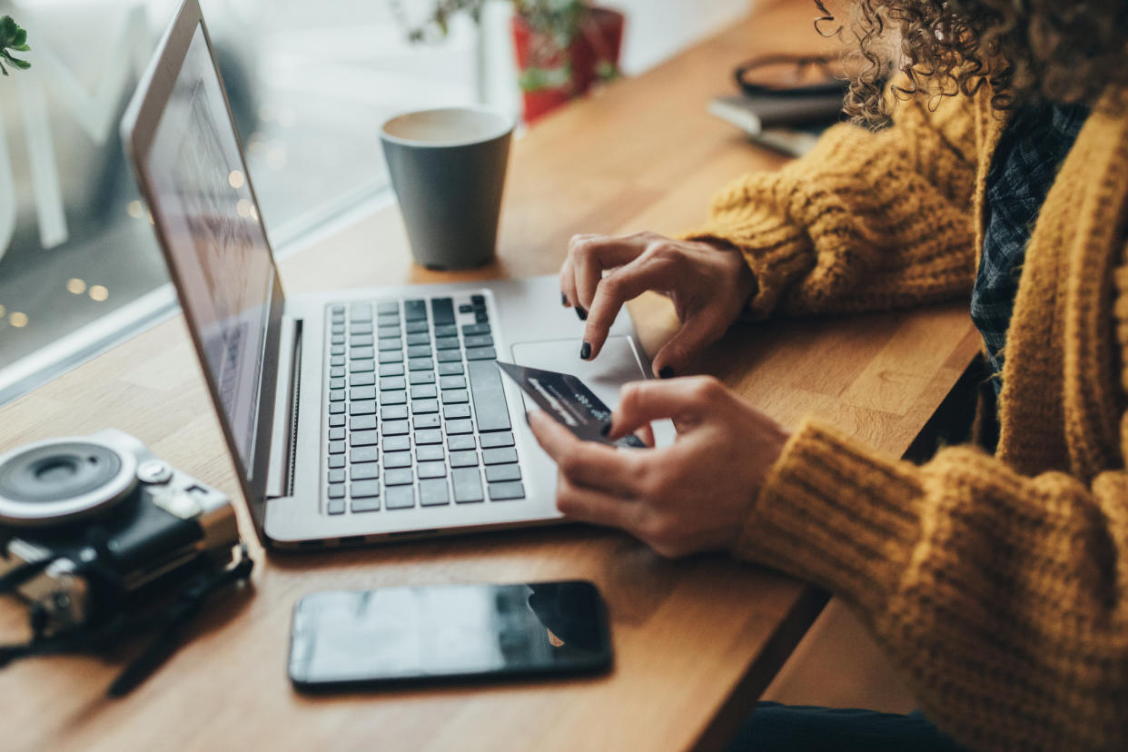 Woman in cafe shopping online with laptop. (PHOTO: Getty Images)