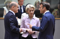 German Chancellor Olaf Scholz, left, speaks with European Commission President Ursula von der Leyen, center, and French President Emmanuel Macron during a round table meeting at an EU summit in Brussels, Thursday, June 23, 2022. European Union leaders are expected to approve Thursday a proposal to grant Ukraine a EU candidate status, a first step on the long toward membership. The stalled enlargement process to include Western Balkans countries in the bloc is also on their agenda at the summit in Brussels. (AP Photo/Geert Vanden Wijngaert)