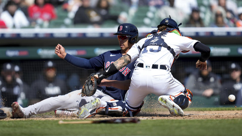 Boston Red Sox's Rob Refsnyder scores as Detroit Tigers catcher Eric Haase (13) can't handle the throw on a Justin Turner sacrifice fly in the seventh inning of a baseball game in Detroit, Sunday, April 9, 2023. (AP Photo/Paul Sancya)