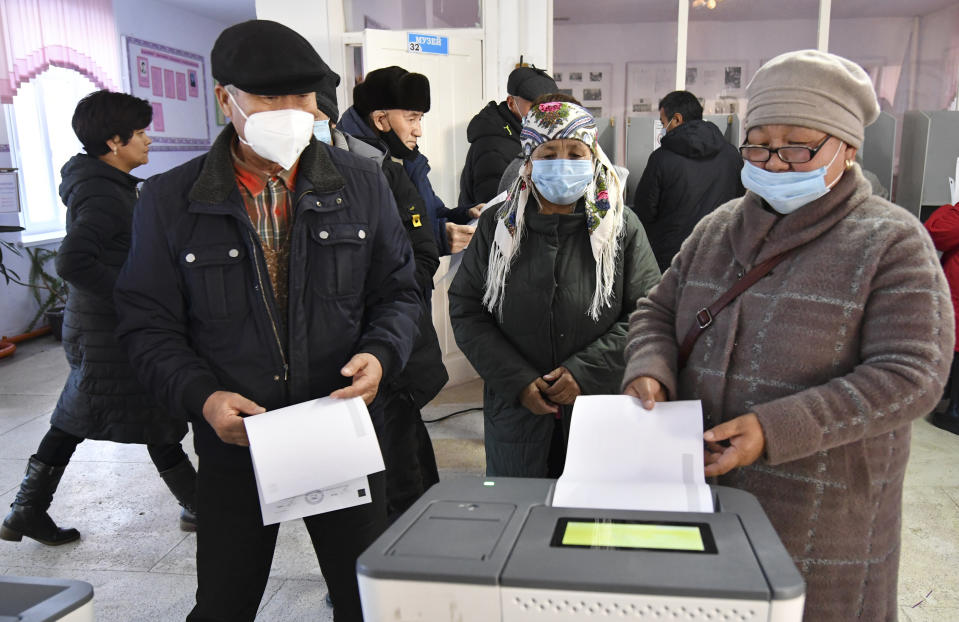 People vote during the parliamentary elections at a polling station in Koy-Tash village, about 16 kilometers (10 miles) south of Bishkek, Kyrgyzstan, Sunday, Nov. 28, 2021. Voters in Kyrgyzstan are casting ballots in a parliamentary vote Sunday that comes just over a year after a forceful change of government in the ex-Soviet Central Asian nation. (AP Photo/Vladimir Voronin)