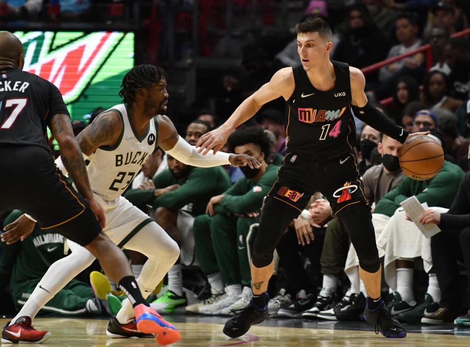 Miami Heat guard Tyler Herro (14) dribbles the ball as Milwaukee Bucks guard Wesley Matthews (23) defends.