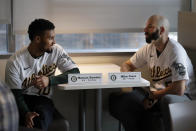 Oakland Athletics pitcher Mike Fiers, right, speaks with shortstop Marcus Semien prior to an interview with the media on Friday, Jan. 24, 2020, in Oakland, Calif. Fiers, the Oakland pitcher and whistleblower in the Houston Astros sign-stealing scandal, appeared with teammates and manager Bob Melvin at team offices. Fiers has not spoken publicly about the sign stealing since the story was published in The Athletic in November. (AP Photo/Ben Margot)