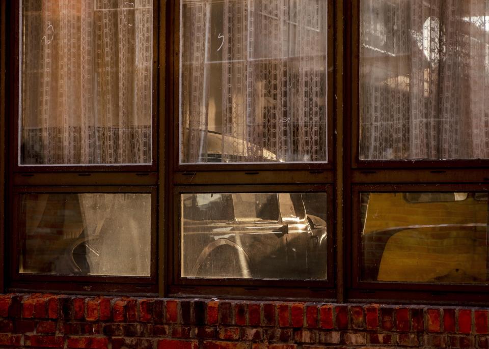 Old-timer cars are seen behind curtains in small production building of the former East German VEB car factory where BMW and Wartburg cars were built in Eisenach, eastern Germany, Tuesday, Sept. 22, 2020. The factory was closed in 1991. Thirty years after Germany was reunited on Oct. 3, 1990, many once-decrepit city centers in the formerly communist east have been painstakingly restored and new factories have sprung up. But many companies and facilities didn't survive the abrupt transition to capitalism inefficient companies found themselves struggling to compete in a market economy, while demand for eastern products slumped and outdated facilities were shut down. (AP Photo/Michael Probst)