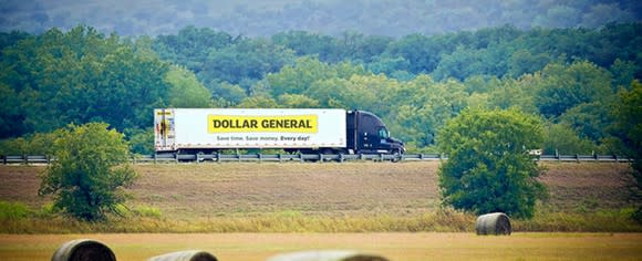 Dollar General freight truck driving in a mountain valley.