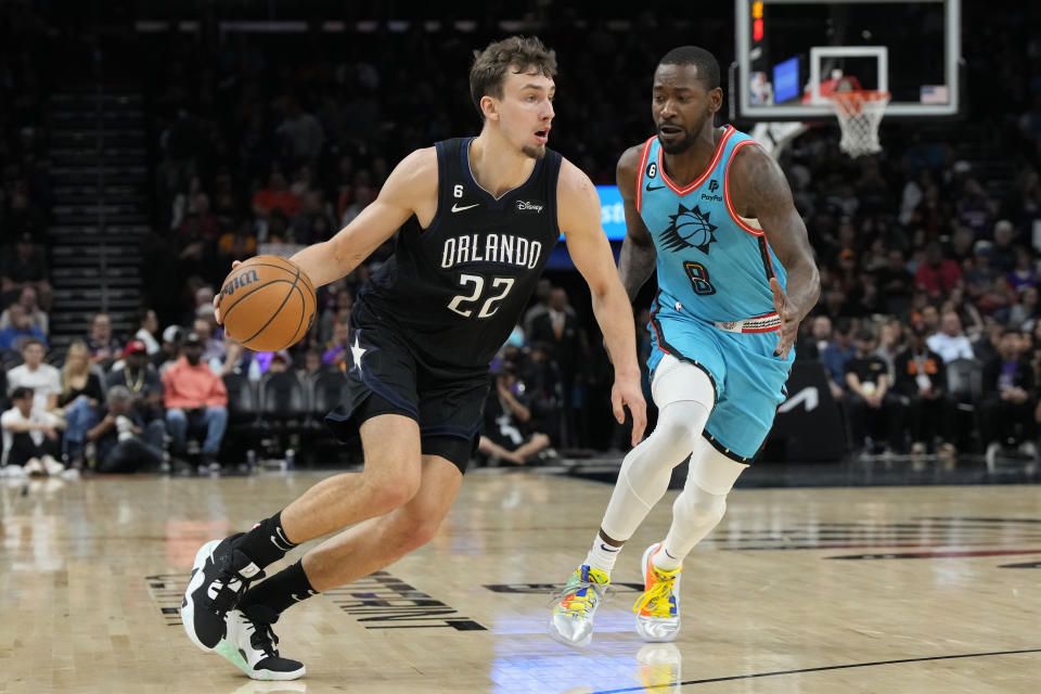 Orlando Magic forward Franz Wagner drives past Phoenix Suns guard Terrence Ross (8) during the first half of an NBA basketball game, Thursday, March 16, 2023, in Phoenix. (AP Photo/Rick Scuteri)