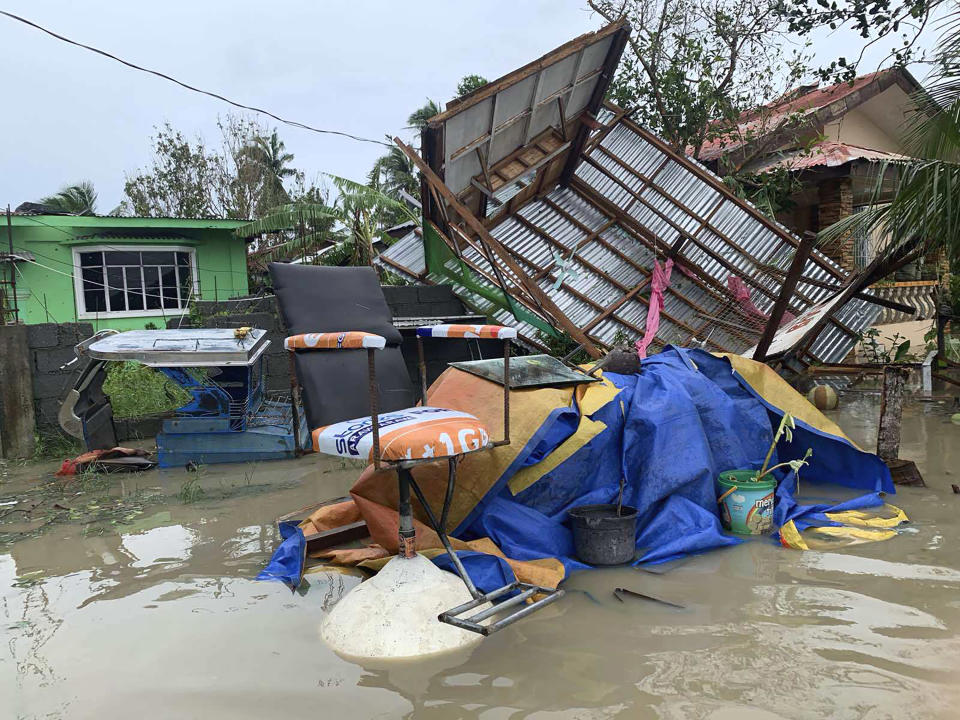 The remains of a barbershop is surrounded by floods in Pola town on the island of Mindoro, central Philippines, Monday, Oct. 26, 2020. A fast-moving typhoon forced thousands of villagers to flee to safety in provinces south of the Philippine capital Monday, flooding rural villages and ripping off roofs, officials said. (AP Photo/Erik De Castro)