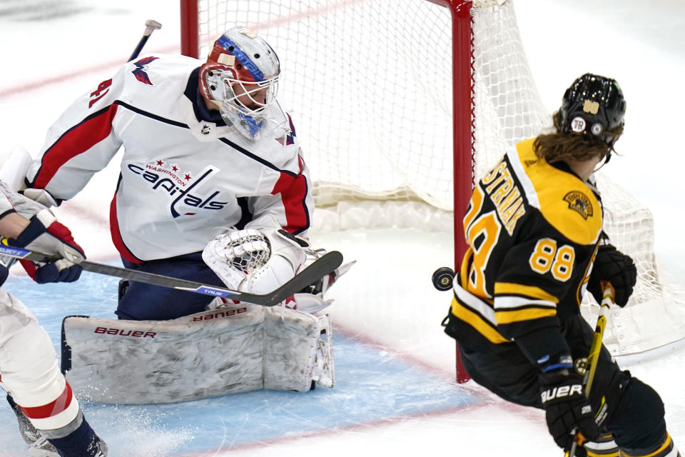 Washington Capitals goaltender Vitek Vanecek, looks back as the puck hits the post after a shot by Boston Bruins right wing David Pastrnak (88) during the first period of an NHL hockey game, Wednesday, March 3, 2021, in Boston. (AP Photo/Charles Krupa)