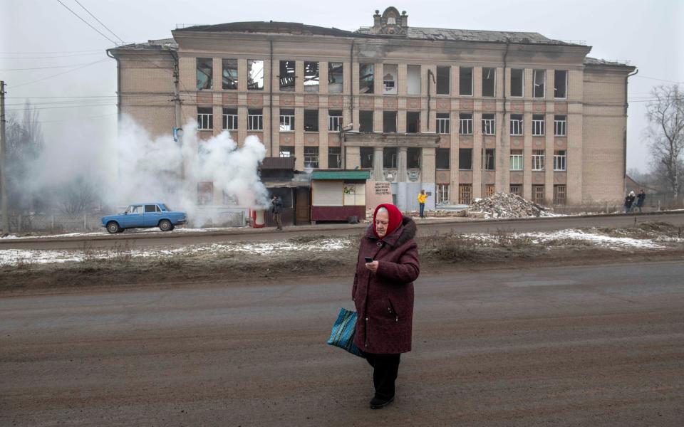 A woman crosses the road in Kostiantynivka to get humanitarian food aid - JULIAN SIMMONDS/JULIAN SIMMONDS