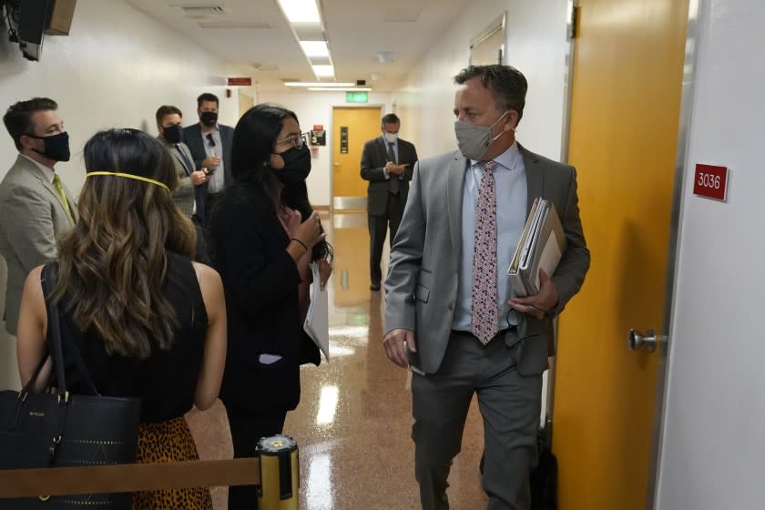 FILE— In this Sept. 2, 2021 file photo Democratic State Sen. Josh Newman, of Fullerton, passes lobbyists and activists as he walks to the Senate chambers at the Capitol in Sacramento, Calif. Normally during the final day before the Legislature breaks for the year, the hallways of the Capitol are filled with people advocating for various bills. But this year lawmakers are going through daily coronavirus testing and all people entering the building must wear face masks. Members of the Legislature have until midnight, Friday, Sept. 10, 2021 to finish work on the 2021 legislative session. (AP Photo/Rich Pedroncelli, File)