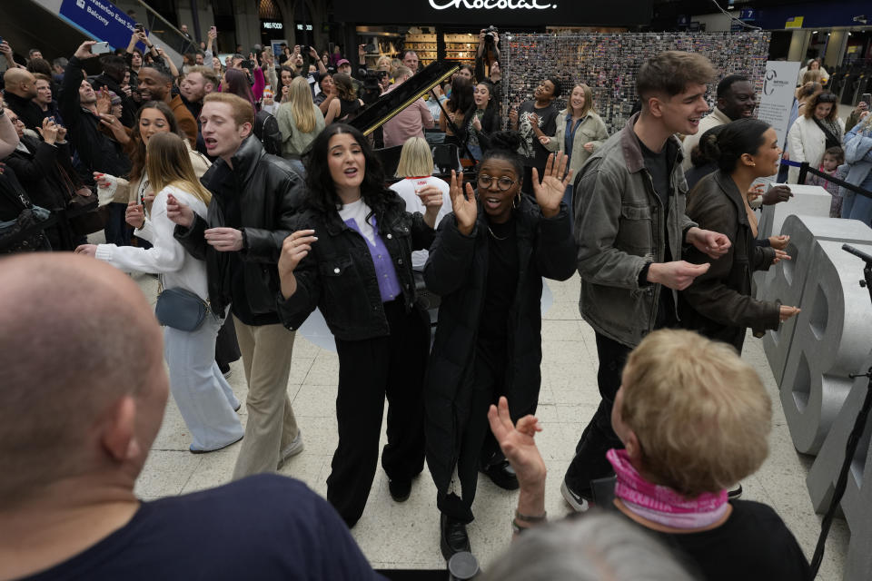 Members of the Mark de Lisser singers preform the iconic ABBA song 'Waterloo' at Waterloo Station in London, Saturday, April 6, 2024. Fans are celebrating 50 years since ABBA won its first big battle with “Waterloo.” A half century ago on Saturday, April 6, the Swedish quartet triumphed at the 1974 Eurovision Song Contest with the peppy love song. (AP Photo/Alastair Grant)