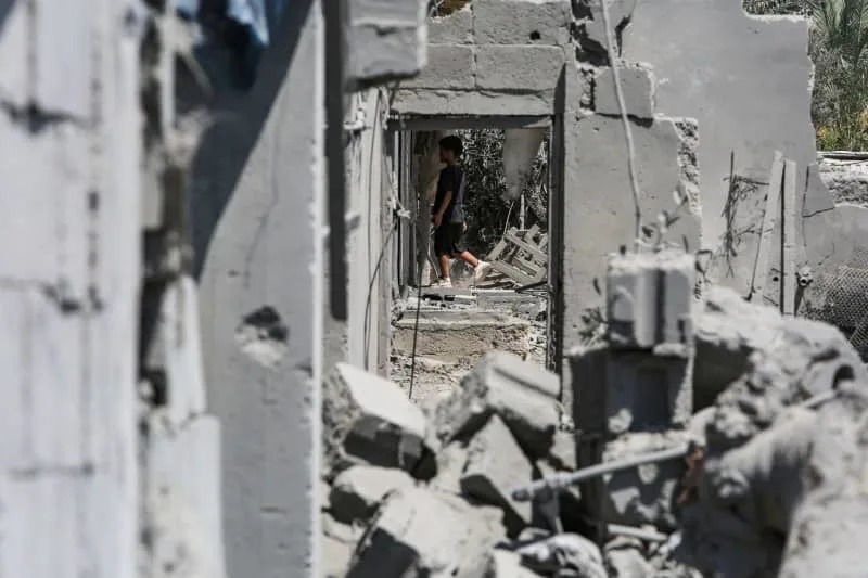 A Palestinian child walks amid the remains of a destroyed building after an Israeli air strike on Khan Younis. Abed Rahim Khatib/dpa