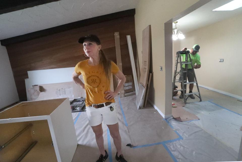 Gwen Wakeman looks at her mother's Port Orange home, which has been damaged and unliveable since Hurricane Ian, on Tuesday. Nancy Moore-Fabian has had to move five times and been out of her home for nearly 18 months thanks to a fraudulent contractor, police say.