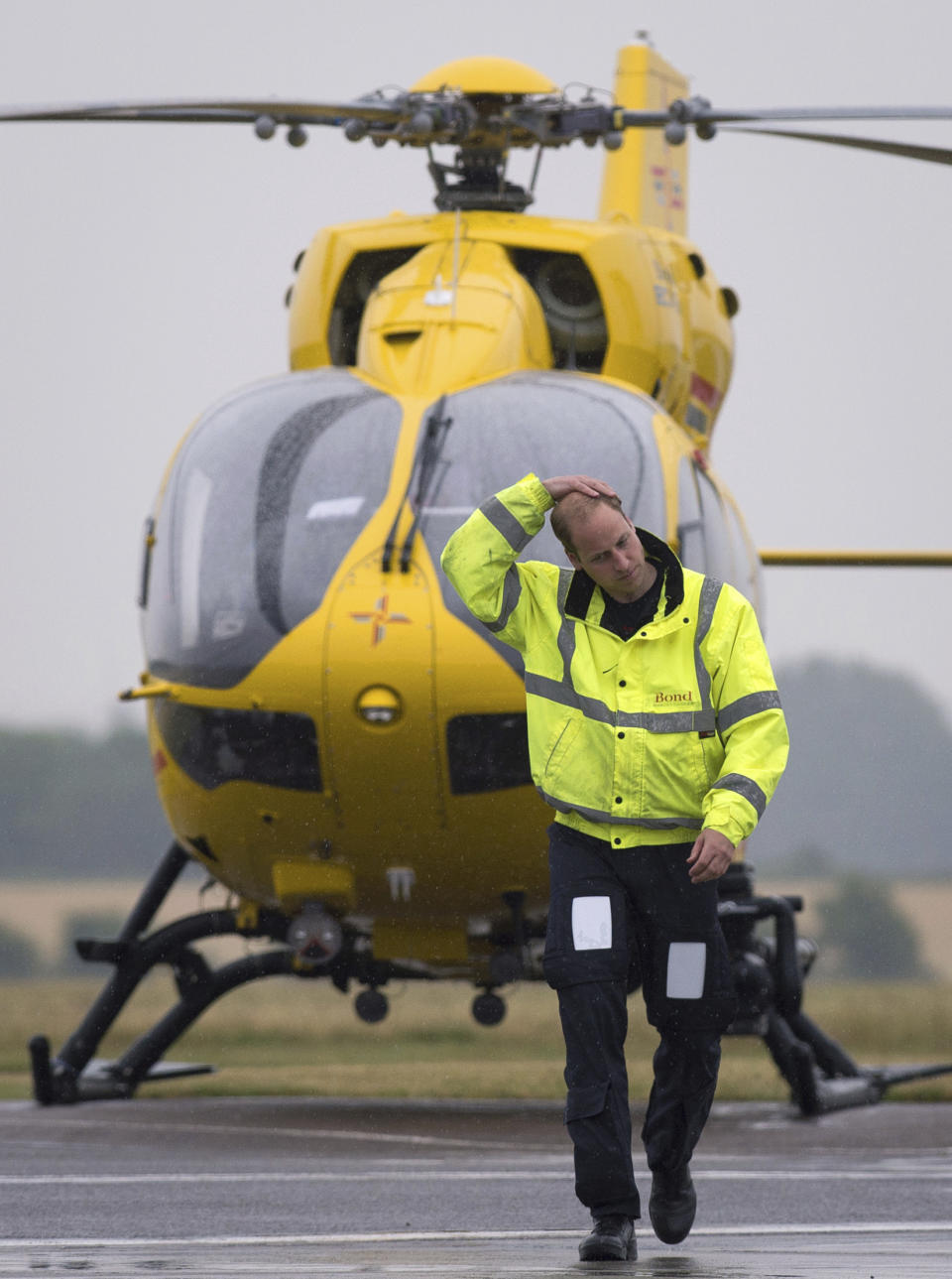 ARCHIVO - El príncipe Guillermo de Gran Bretaña, duque de Cambridge, con una ambulancia aérea de East Anglian (EAAA) al fondo, comienza su nuevo cargo, en el aeropuerto de Cambridge, Inglaterra, el 13 de julio de 2015. (Stefan Rousseau, Pool vía AP, archivo)