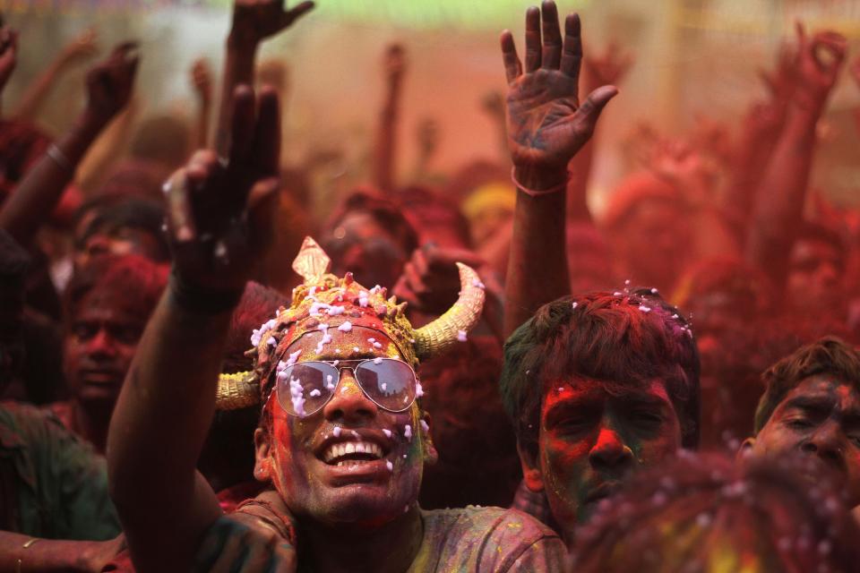 Indians, faces smeared with colored powder and foam, dance during celebrations marking Holi, the Hindu festival of colors, in Gauhati, India, Monday, March 17, 2014. The festival also marks the advent of spring. (AP Photo/Anupam Nath)