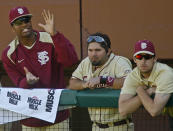 At left, Florida State relief pitcher Jameis Winston (44) claps from the dugout in the sixth inning of an NCAA college baseball game against Miami on Sunday, March 2, 2014, in Tallahassee, Fla. Florida State's Ladson Montgomery is in the middle. Florida State won 13-6. (AP Photo/Phil Sears)