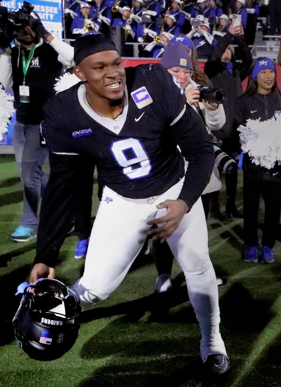 Defensive end Jordan Ferguson (9) rolls his helmet into the MTSU football players on the sidelines as MTSU celebrates being bowl eligible after beating Florida Atlantic on Nov. 19, 2022.