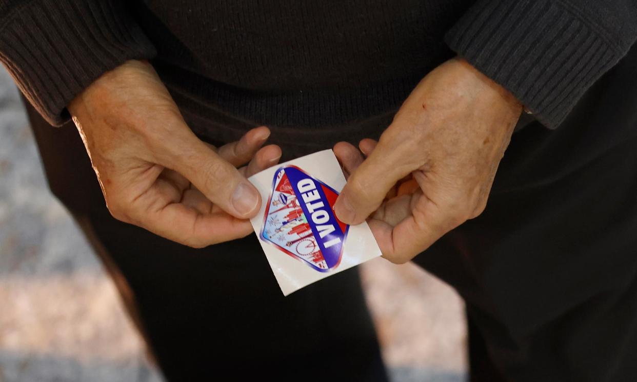 <span>A person holds a voting sticker in Las Vegas, Nevada, on Tuesday.</span><span>Photograph: Caroline Brehman/EPA</span>