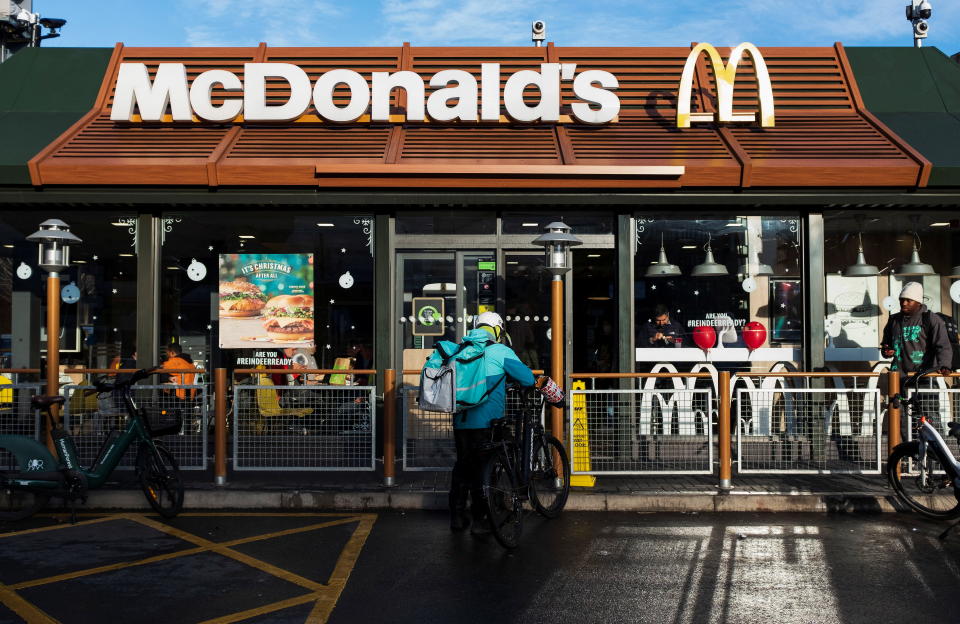 A Deliveroo rider stands beside a bicycle outside a McDonald's restaurant in London, Britain, December 10, 2021. Picture taken December 10, 2021. REUTERS/May James