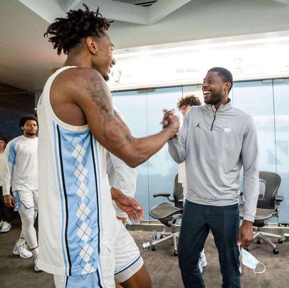 Leaky Black, left, and Jackie Manuel greet each other in the North Carolina locker room while celebrating the Tar Heels’ overtime victory against Syracuse in the final week of the regular season.