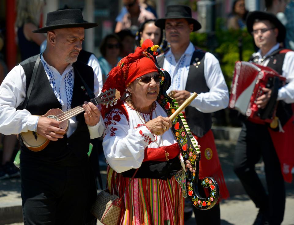 Joyce Neves, of Rancho Folclorico de Nossa Senhora de Fatima in Cumberland, Rhode Island, plays what she calls "Mr. Rooster," a rhythm instrument. The Portuguese dancers and musicians performed in Lopes Square in Provincetown before the blessing of the fleet procession. 
The 75th Blessing of the Fleet, part of the 25th anniversary of the Portuguese Festival was held Sunday. The statue of St. Peter was carried from St. Peter the Apostle Church to MacMillan Pier.