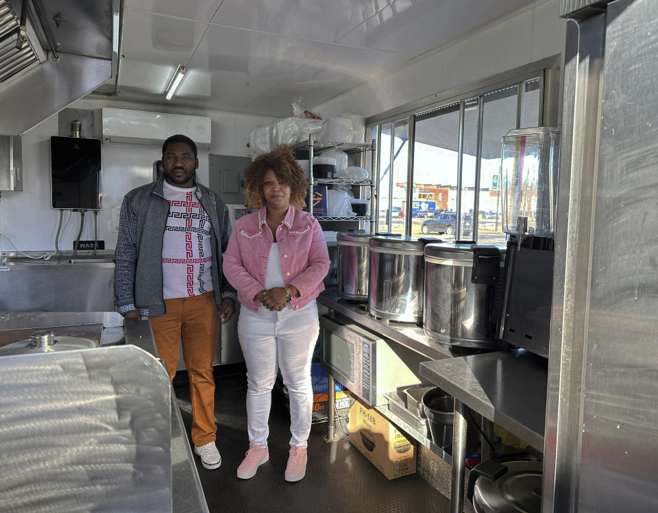 Theslet Benoir and Clemene Bastien stand inside their Eben-Ezer Haitian food truck in Parksley, Va., on Wednesday, Jan. 24, 2024. The married couple is suing the town in federal court over allegations that their food truck was forced to close. The couple also says a town councilman cut the mobile kitchen's water line and screamed, "Go back to your own country!" (AP Photo/Ben Finley)