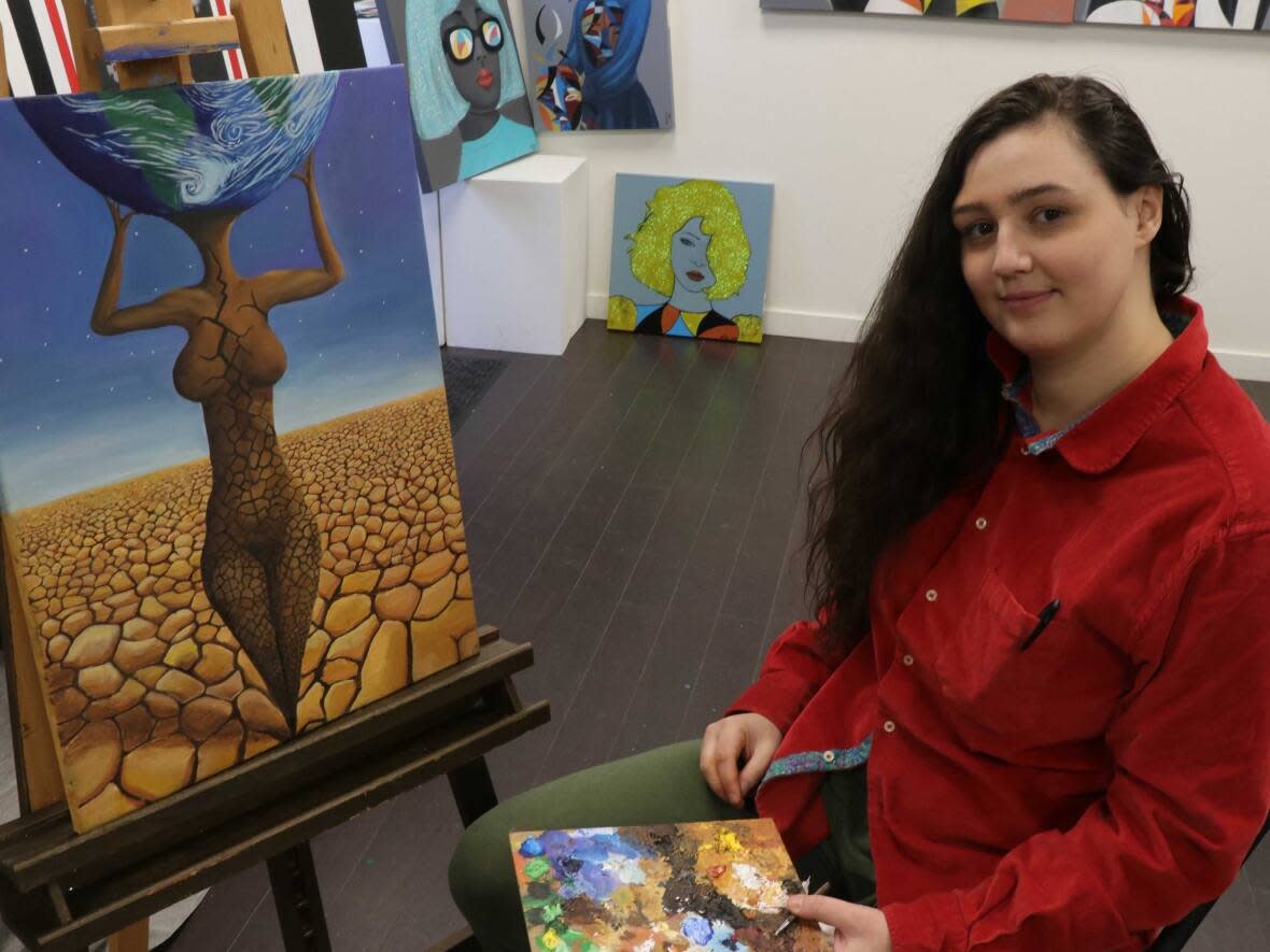 Artist Inanna Cusi says her painting of a woman's cracking body holding up the earth symbolizes women's strength and vulnerability. (Rafe Arnott/CBC - image credit)