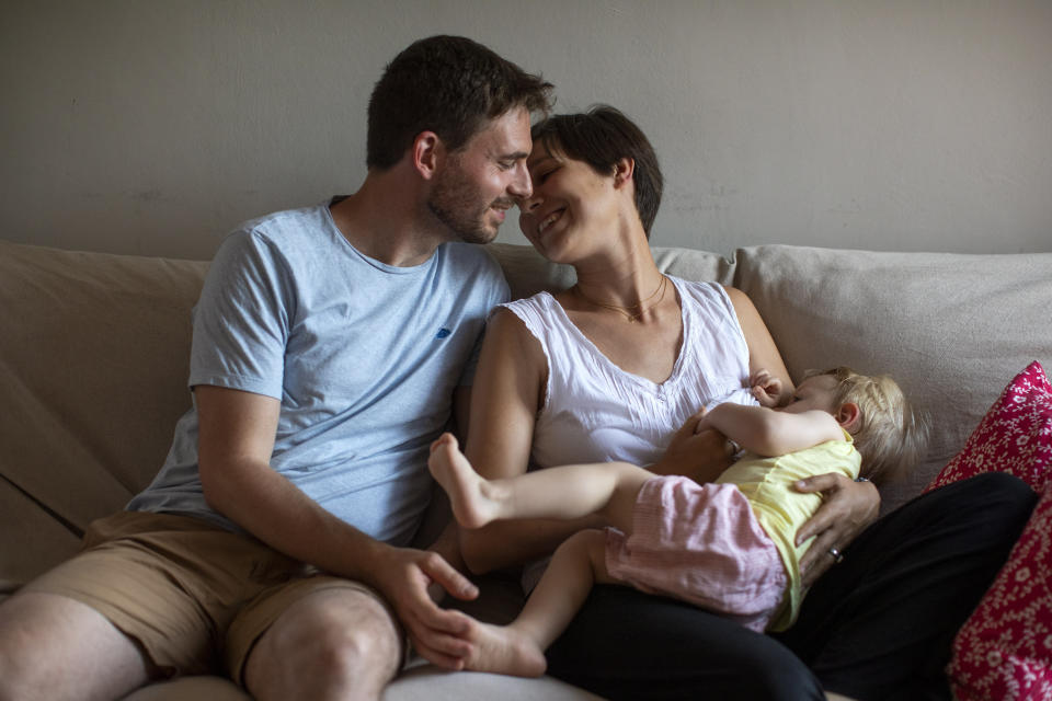 In this photo taken on Wednesday, June 19, 2019, Clara Massons feeds her two years old son Jaume next to her husband Toni, at her home in Barcelona, Spain. Outdated medical practices related to childbirth that continue to be used despite evidence they cause harm have come under increasing scrutiny in Europe. (AP Photo/Emilio Morenatti)