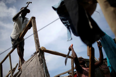 Men repair a damaged house after Hurricane Matthew passes in Jeremie, Haiti, October 9, 2016. REUTERS/Carlos Garcia Rawlins