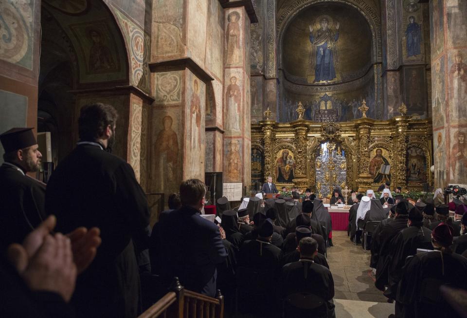 Ukrainian President Petro Poroshenko, background center, speaks at a closed-door synod of three Ukrainian Orthodox churches to approve the charter for a unified church and to elect leadership in the St. Sophia Cathedral in Kiev, Ukraine, Saturday, Dec. 15, 2018. Poroshenko has told the crowd "the creation of our Church is another declaration of Ukraine's independence and you are the main participants of this historic event." (Mykhailo Markiv, Ukrainian Presidential Press Service/Pool Photo via AP)