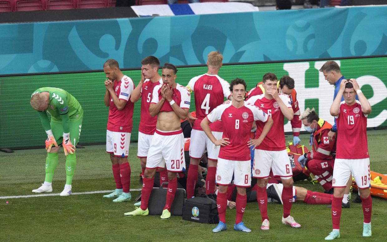Denmark's players react as paramedics attend to Denmark's midfielder Christian Eriksen after he collapsed on the pitch during the UEFA EURO 2020 Group B football match between Denmark and Finland at the Parken Stadium in Copenhagen on June 12, 2021