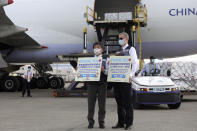 In this photo released by the Taiwan Centers for Disease Control, Taiwan's Health Minister Chen Shih-chung, left, and Brent Christensen, the top U.S. official in Taiwan, hold up thank you cards as they welcome a China Airlines cargo plane carrying COVID-19 vaccines from Memphis that arrived at the airport outside Taipei in Taiwan Sunday, June 20, 2021. The U.S. sent 2.5 million doses of the Moderna COVID-19 vaccine to Taiwan on Sunday, tripling an earlier pledge in a donation with both public health and geopolitical meaning. (Taiwan Centers for Disease Control via AP)