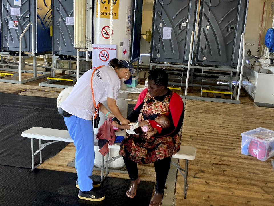 An MSF (Doctors Without Borders) medic checks an infant after being rescued from the Mediterranean Sea, off Libya, in the central Mediterranean route, Monday, Sept. 20, 2021. (AP Photo/Samy Magdy)