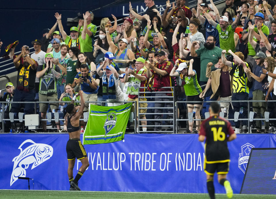 Seattle Sounders midfielder Léo Chú, left, celebrates his goal against the Portland Timbers with fans as midfielder Alex Roldan (16) runs over to join him during the first half of an MLS soccer match Saturday, Sept. 2, 2023, in Seattle. (AP Photo/Lindsey Wasson)